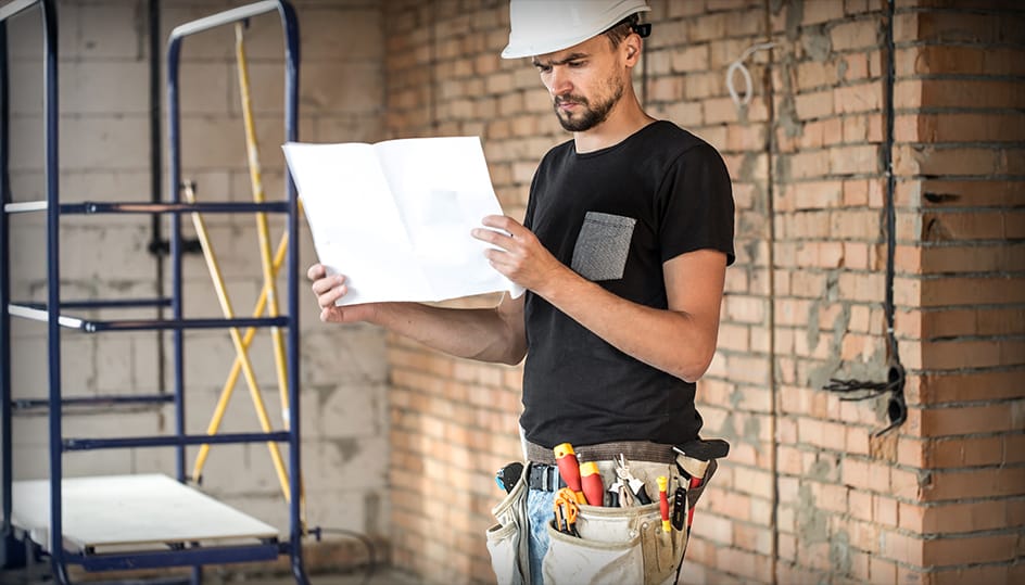 Vakman bekijkt bouwplan tijdens renovatieproject. Zorgvuldige voorbereiding en professioneel vakmanschap door FB Bouwdiensten.