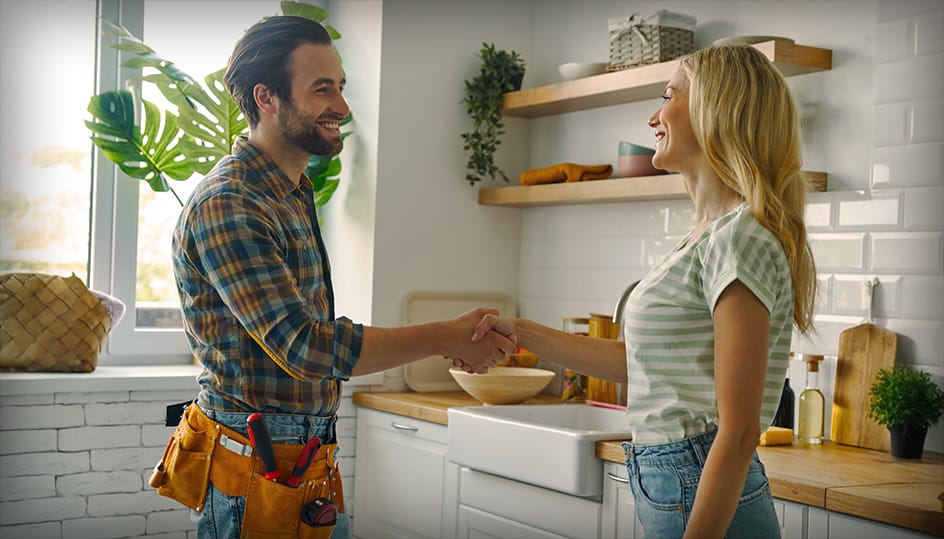 Tevreden klant schudt hand met vakman in moderne keuken. Succesvolle samenwerking en betrouwbare service van FB Bouwdiensten.
